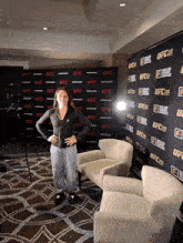 a woman stands in front of a wall that says ufc on it