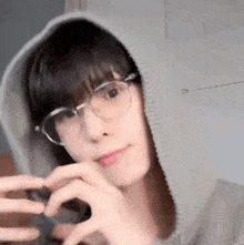 a man wearing glasses and a hoodie is taking a selfie .