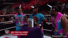 a group of wrestlers standing in a wrestling ring with a sign that says see this full video