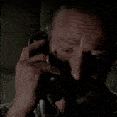 a man with a ring on his finger is covering his mouth while talking on a telephone