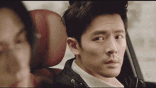 a man in a car with a woman in the back seat