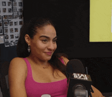 a woman sitting in front of a microphone that says real 823 on it