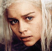 a close up of a blonde woman 's face with blue eyes