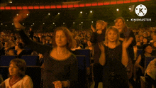 a crowd of people applauding in front of a sign that says " kinemaster "