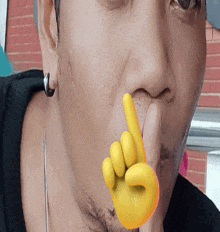 a close up of a man 's face with a yellow finger on his mouth