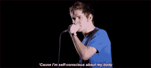 a man is singing into a microphone and says `` cause i 'm self-conscious about my body ''