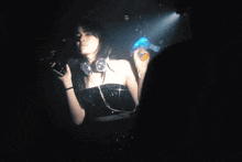 a woman is wearing headphones and holding a bottle in her hand