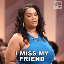 a woman in a blue dress is saying i miss my friend