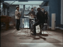 a group of men are playing instruments in a dark room