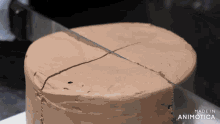 a chocolate cake is being sliced by a knife and the words made in animotica are on the bottom