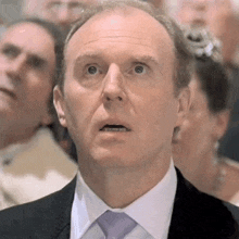 a man in a suit and tie is looking up with his mouth open