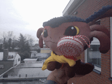 a stuffed animal with a scarf around its neck is holding a lollipop