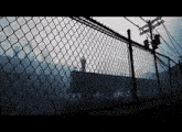 a chain link fence is surrounded by telephone poles and power lines