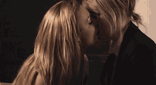 a man and a woman are kissing in a room .
