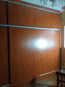 a wooden wall with a chandelier hanging above it