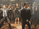 a group of men in suits and ties are dancing on a dance floor