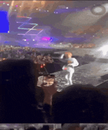 a person is taking a picture of a person on a stage at a concert