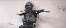 a person in a military uniform holding a rifle with a website written on the bottom