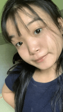 a close up of a young woman 's face with a blue shirt on
