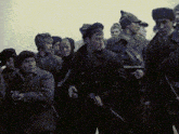 a group of soldiers are standing in a line and one of them is holding a gun