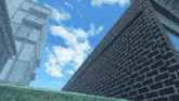 looking up at a brick wall with a blue sky in the background