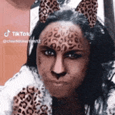 a woman with leopard print on her face and ears is making a face .