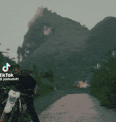 a man is riding a dirt bike on a road with the words hey r name on the bottom