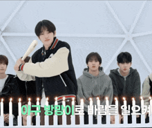 a boy is holding a baseball bat in front of a row of candles in korean