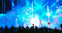 a crowd of people taking pictures of a kenny com concert