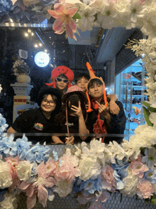 a group of people are posing for a picture in front of a floral frame