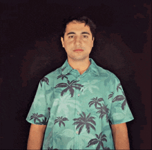 a man is wearing a shirt with palm trees on it