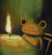 a frog is sitting next to a candle with a flame