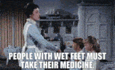a woman is talking to two children in a room and says `` people with wet feet must take their medicine '' .