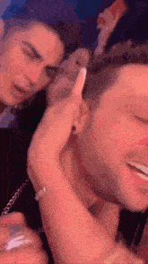 a couple of men are standing next to each other and one of them is holding something in his hand