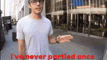 a man standing in front of a building with the words " i 've never partied once " above him
