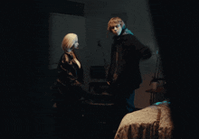 a man and woman are standing in a dark room