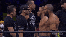 a group of men in a wrestling ring with one wearing a black shirt that says captain