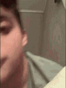 a close up of a man 's face looking at himself in a mirror .