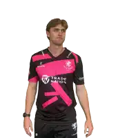 a man wearing a pink and black shirt that says trade nation on it