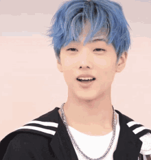 a young man with blue hair is wearing a white shirt and a black jacket .
