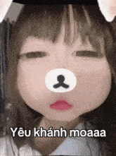 a girl with a teddy bear face on her face is making a funny face .