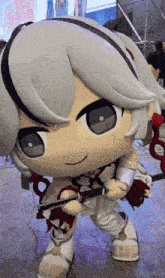 a stuffed doll is holding a sword and wearing white pants