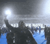 a group of people standing in front of a sign that says " blue boys "