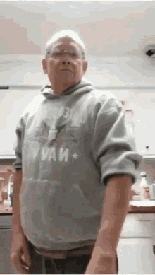 an elderly man wearing a gray hoodie with the word paw on it