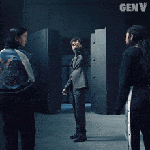a poster for genv shows three people standing in front of a vault door