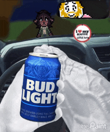 a person holding a can of bud light in front of a steering wheel