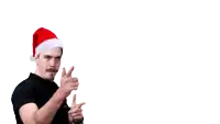 a man wearing a santa hat is pointing at a candy cane