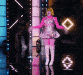 a woman in a pink dress and white boots is standing in front of a mirror