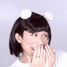 a man wearing a wig and a headband with pom poms on it is laughing .