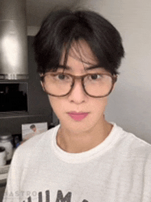 a man wearing glasses and a white shirt is looking at the camera .
